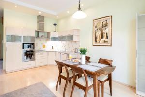 a kitchen with a wooden dining table and chairs at Spacious apartment with cozy balcony by URBAN RENT in Vilnius
