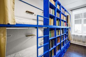 een kamer met blauwe planken gevuld met boeken bij BookCase Hostel in Sint-Petersburg