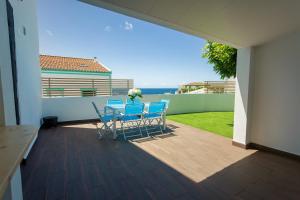 a patio with chairs and a table on a balcony at Castanheiro in Lagoa