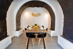 a dining room with a table and chairs under an archway at Castanheiro in Lagoa