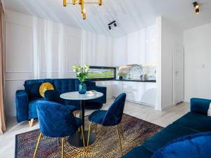 a living room with blue chairs and a table at Blu Port in Gąski
