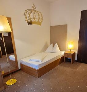 um quarto com uma cama com um espelho e um candeeiro em Hotel Kaiser Franz Josef em Rohr im Gebirge