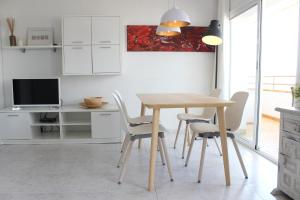 a dining room with a wooden table and chairs at Beautiful apartment in front of beach, pool, view in Roses