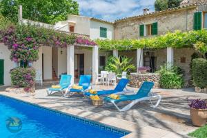 a villa with a swimming pool and blue lounge chairs at Finca L'hort de Can Bota,con piscina privada in Pollença