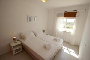 une chambre blanche avec un lit et une fenêtre dans l'établissement Villa Alvor 6 by amcf, à Alvor