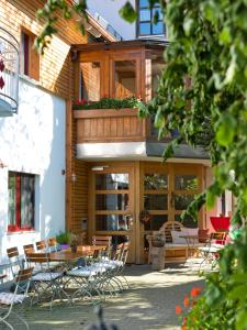 un patio con tavolo e sedie di fronte a un edificio di Landgasthof Lusenblick a Grafenau