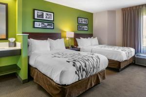 two beds in a hotel room with green walls at Sleep Inn Allentown-Fogelsville in Allentown