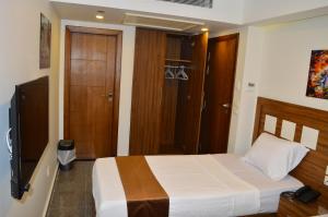 a bedroom with a bed and a television in it at Royal Inn Residence in Cairo