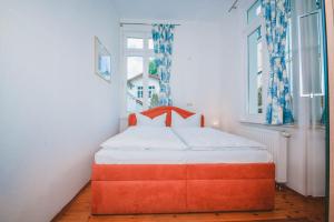 - une chambre avec un lit orange devant une fenêtre dans l'établissement Haus Mertin Whg 1 Seestern, à Heringsdorf