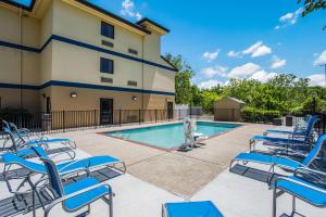 a pool with chairs and a fountain in front of a building at Clarion Pointe Franklin - Nashville Area in Franklin