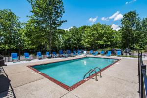 a swimming pool with blue lounge chairs around it at Clarion Pointe Franklin - Nashville Area in Franklin