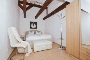 ein Schlafzimmer mit einem weißen Bett und einem Stuhl in der Unterkunft Haus Mertin Whg 4 Seepferdchen in Heringsdorf