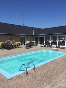 a large swimming pool in front of a house at Skuldelev kro in Skibby