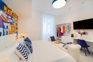 a white bedroom with a large bed and a tv at Amalfi Centro in Amalfi