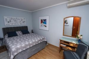 a bedroom with a bed and a mirror and a chair at Apartment Klaudia 4 STARS in Poreč