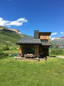 une cabane en rondins avec une table et des chaises dans un champ dans l'établissement Chalet Reymond Pre du lac, à Tignes