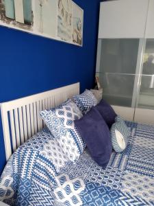 Una cama con almohadas azules y blancas. en BRAVAHOLIDAYS-283-Palmeras-3, en Blanes