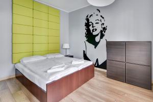 um quarto com uma cama com um quadro na parede em Grand Apartments - Davos Apartment Gdańsk Szafarnia River View em Gdansk
