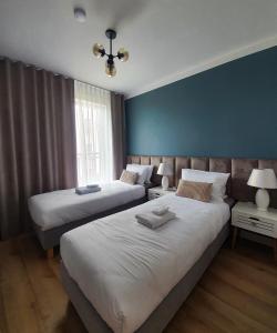 - 2 lits dans une chambre avec un mur bleu dans l'établissement Może Morze - Rezydencja Ustronie Morskie, à Ustronie Morskie
