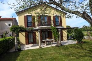 a large yellow house with a table in a yard at Apartment Klaudia 4 STARS in Poreč