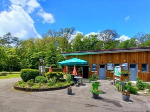 a building with a table and a blue umbrella at Camping de Contrexeville in Contrexéville