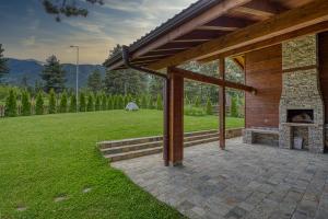 um pátio exterior com uma lareira num quintal em Pirin Style Villa & Spa em Bansko