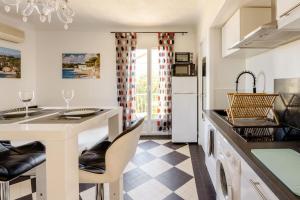 a kitchen with a counter and a kitchen island with chairs at Studio Antibes - 5min des plages - Parking gratuit - Climatisation in Antibes