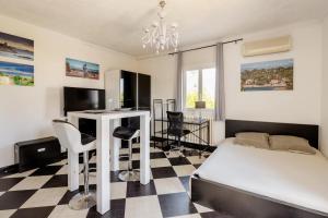 a bedroom with a bed and a desk with a computer at Studio Antibes - 5min des plages - Parking gratuit - Climatisation in Antibes