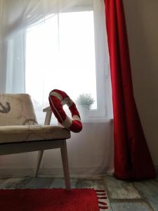 バラトンレッレにあるBoathouse Balatonlelle with Sauna & Salty Bath Tubの椅子と赤いカーテン付きの部屋