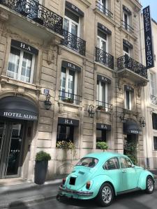une voiture bleue garée devant un bâtiment dans l'établissement HOTEL ALISON, à Paris