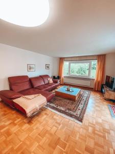 ein Wohnzimmer mit einem roten Sofa und einem Tisch in der Unterkunft Grüntenblick in Kempten