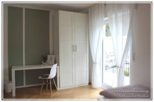 Zimmer mit einem Schreibtisch, einem Stuhl und einem Fenster in der Unterkunft Schöne 4-Zimmerwohnung, Schlangenbad bei Wiesbaden/Mainz/FFM in Schlangenbad