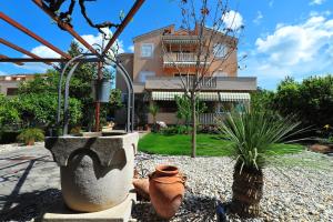 een tuin met een gebouw op de achtergrond bij APARTMANI VILLA ELVIRA in Sukošan +25 foto's