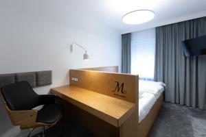 Dębno PolskieにあるHotel Mariaのデスクと椅子が備わるホテルルームです。