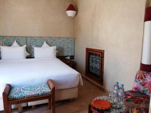 a bedroom with a bed, a table and a lamp at Riad Kalaa in Rabat