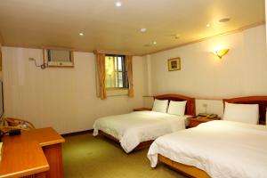 En eller flere senge i et værelse på Lidu Hotel