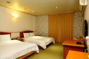 En eller flere senge i et værelse på Lidu Hotel