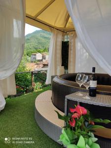 a table with two glasses of wine and a flower at Casa Vittoria in Verni