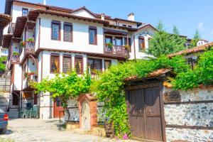 an old house with a gate and vines at Sivrieva House in Zlatograd