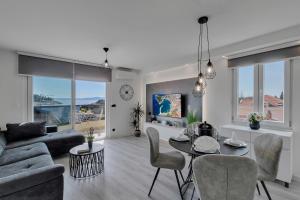 a living room with a couch and a table and chairs at Exclusive Center apartment in Makarska