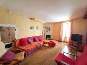 ein Wohnzimmer mit einem roten Sofa und einem TV in der Unterkunft Appartement au coeur du village- Ref12 in Saint-Paul-Trois-Châteaux