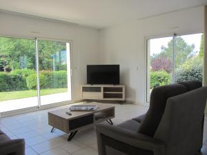 een woonkamer met 2 stoelen en een flatscreen-tv bij La Villa Marina in Donville-les-Bains