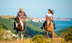 a man and a woman riding horses in a field at Happy Studio Sea View in Topola