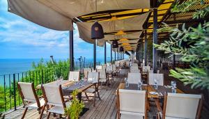 a row of tables and chairs on a patio at Happy Studio Sea View in Topola