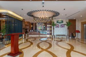 een lobby met een grote kroonluchter in een gebouw bij Emerald Hotel in Jeddah