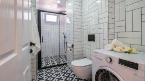 een badkamer met een toilet, een wastafel en een wasmachine bij Kaş Kekik Apart in Yeniköy