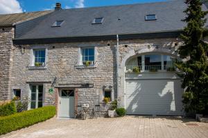 an old stone house with a garage at Les Auges in Beauraing