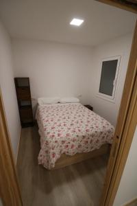 a small bedroom with a bed and a window at Buen Camino Melide in Melide