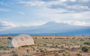 a dome tent in the middle of a field with a mountain at Amanya King Lion 1-Bed Wigwam in Amboseli in Amboseli