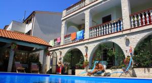 una donna seduta su una sedia accanto alla piscina di Room in Medulin with terrace, air conditioning, WiFi 3488-6 a Medulin